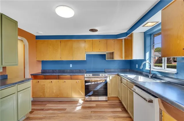 a kitchen with stainless steel appliances granite countertop a sink stove and cabinets