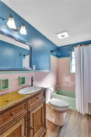 a bathroom with a granite countertop toilet sink and mirror