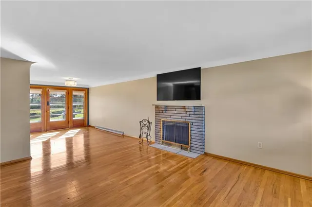 a view of an empty room with a fireplace and a window