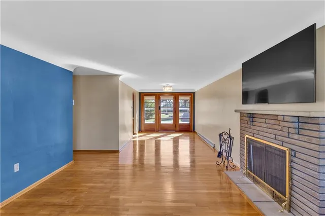 a view of an empty room with a fireplace and a window