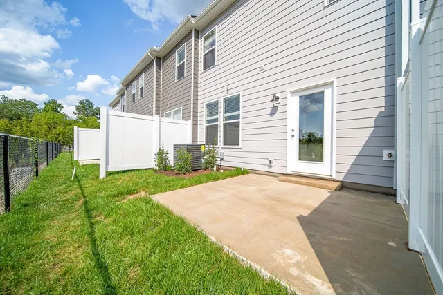 a backyard of a house with plants and barbeque oven