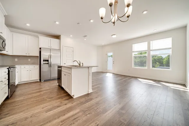 a view of a kitchen with wooden floor and a window