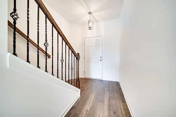a view of a hallway with wooden floor and staircase