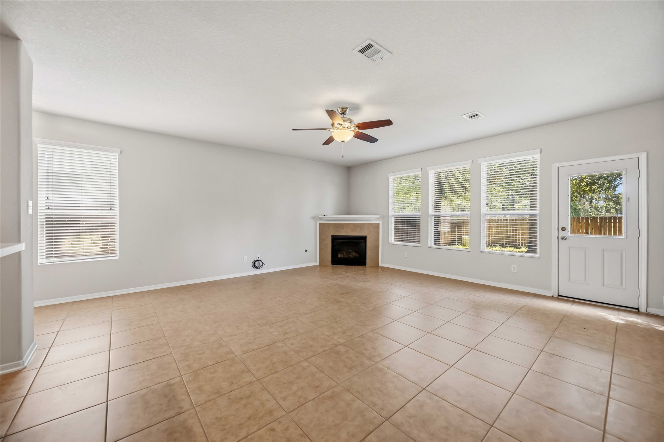 29526 Winton Wood Way Spring, TX 77386 - Photo 5 of 29 Alternate view of this spacious living room showcasing the fireplace, abundant natural light, and backyard access.