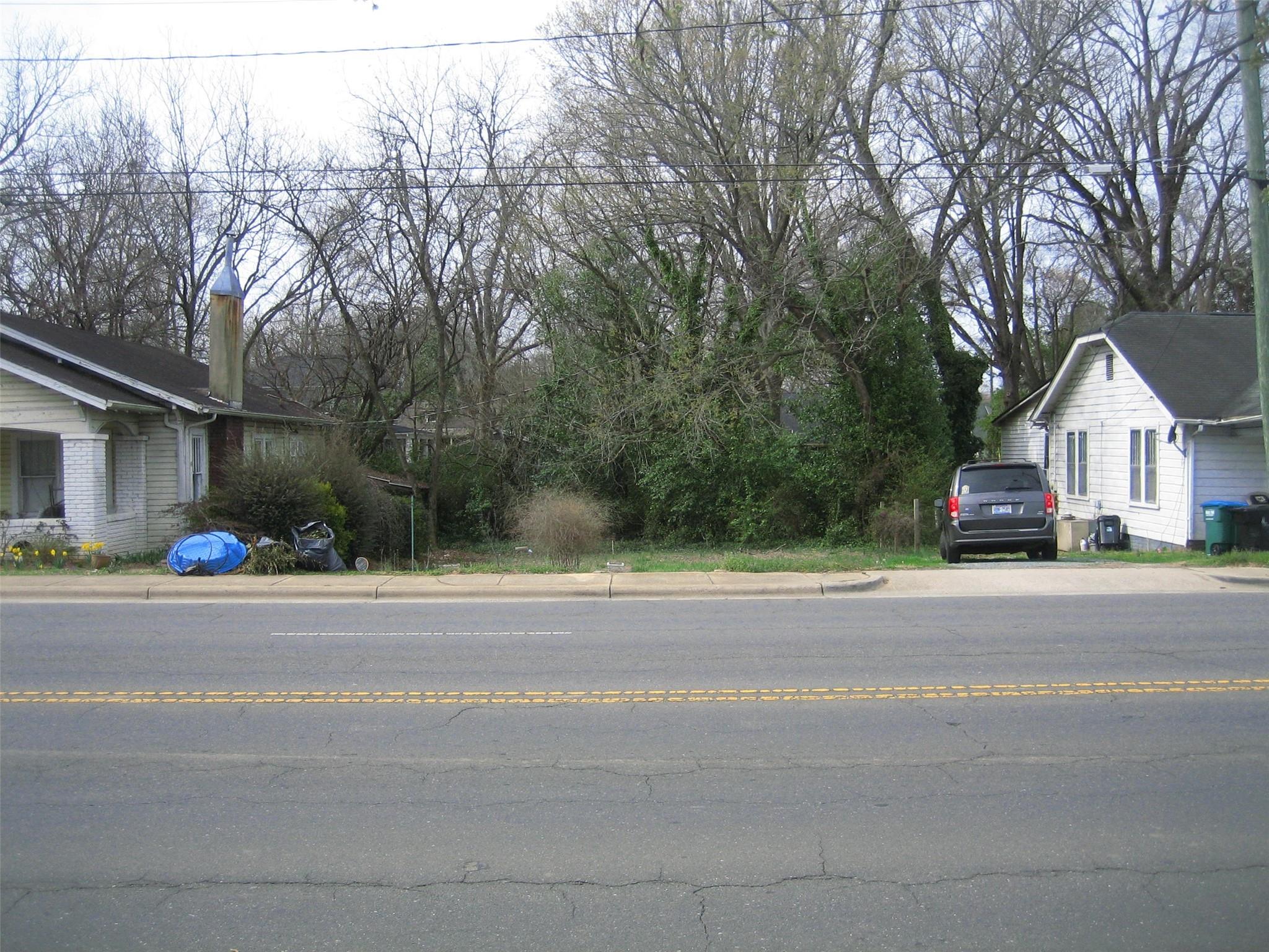 a view of a house with a yard and large trees