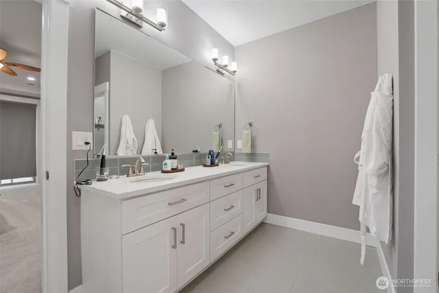 a bathroom with a double vanity sink a mirror and a shower