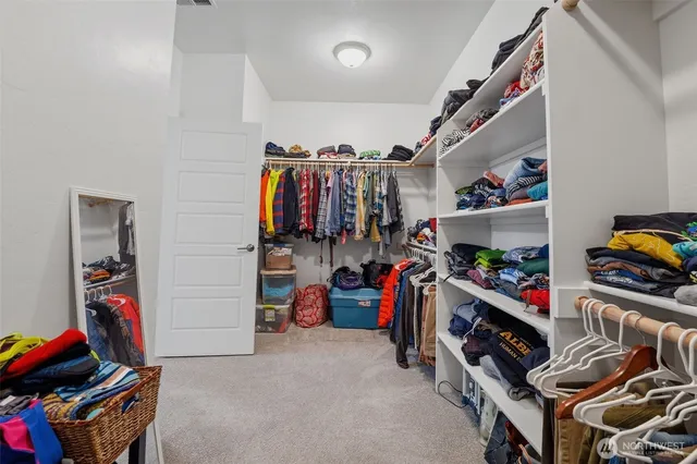 a view of walk in closet with clothes and shoes