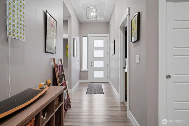 a view of a hallway with workspace and wooden floor