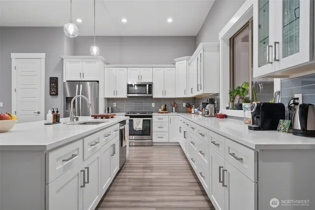 a large kitchen with stainless steel appliances sink a microwave and cabinets
