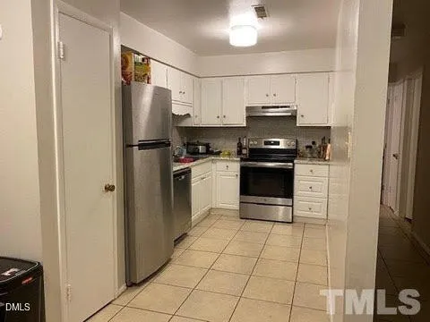 a kitchen with stainless steel appliances granite countertop a stove a refrigerator and a sink