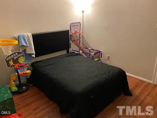 1010 Sandlin Place, Unit E Raleigh, NC 27606 - Photo 8 of 10 a bedroom with a bed and wooden floor