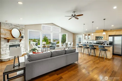 a kitchen with stainless steel appliances granite countertop a table chairs refrigerator and wooden floor