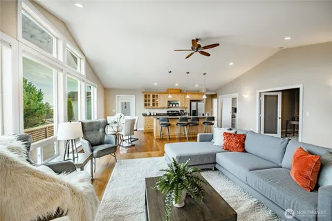a living room with furniture a fireplace and a floor to ceiling window