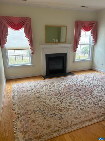 a view of an empty room with a fireplace and a window