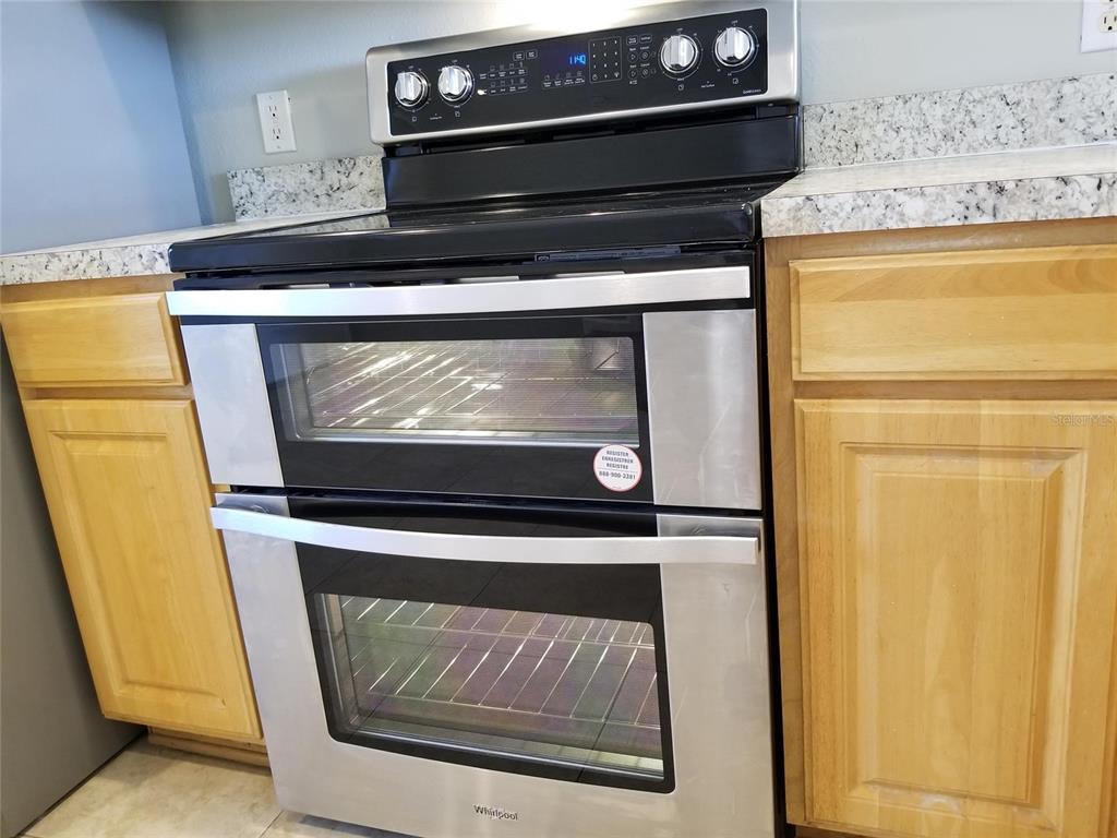 4536 Kennewick Place Riverview, FL 33578 - Photo 15 of 50 a stove top oven sitting inside of a kitchen with stainless steel appliances wooden floor
