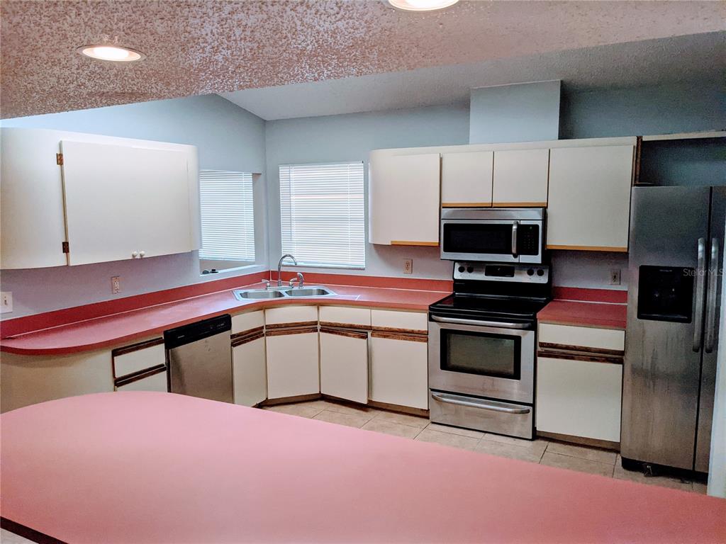 5327 Baldock Avenue Spring Hill, FL 34608 - Photo 3 of 18 a kitchen with a sink cabinets and stainless steel appliances