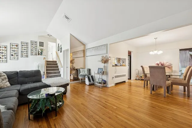 a kitchen with stainless steel appliances granite countertop a refrigerator a stove a sink dishwasher and wooden cabinets with wooden floor