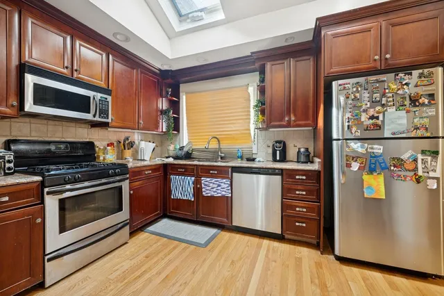 a dining room with furniture wooden floor a rug a potted plant and a chandelier
