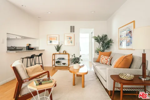 a living room with furniture and a kitchen view