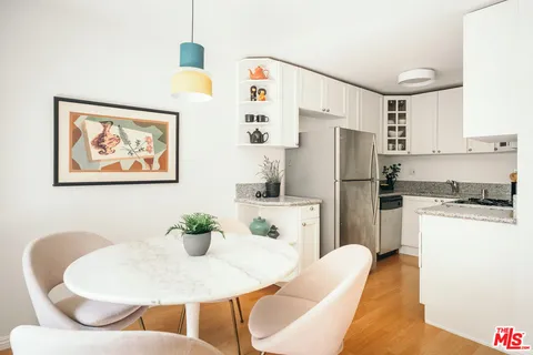 a kitchen with stainless steel appliances granite countertop a dining table and chairs