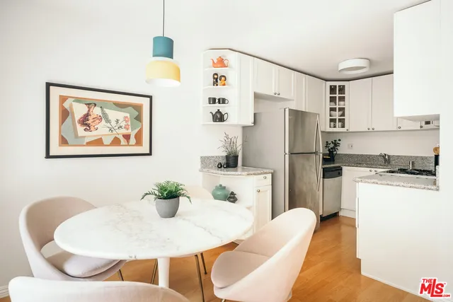 a kitchen with stainless steel appliances granite countertop a dining table and chairs