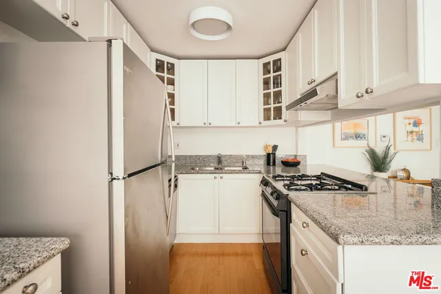 a kitchen with stainless steel appliances granite countertop a refrigerator and a stove