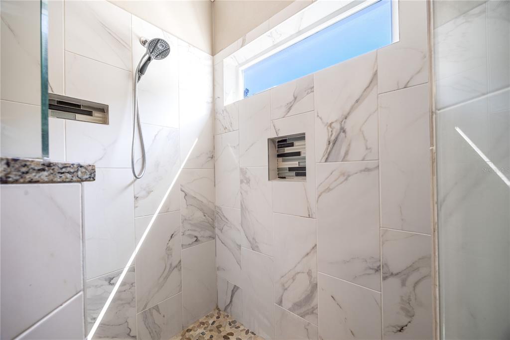 8267 Southwest 78th Lane Gainesville, FL 32608 - Photo 17 of 57 a bathroom with a shower and mirror