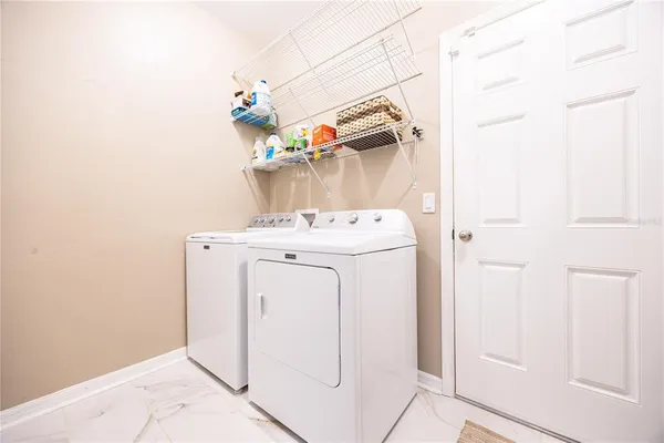 a utility room with stainless steel appliances wooden floor and window