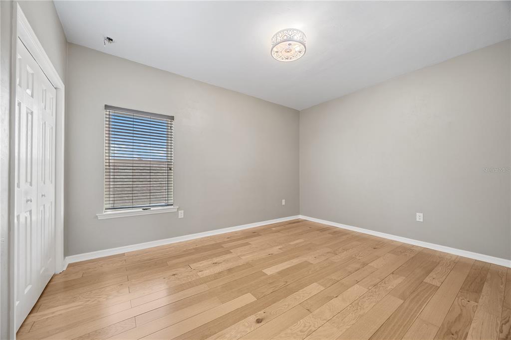 8267 Southwest 78th Lane Gainesville, FL 32608 - Photo 28 of 57 a view of an empty room with wooden floor and a window