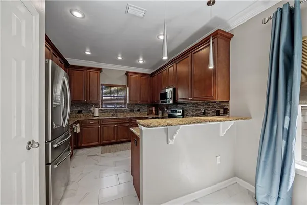 a kitchen with stainless steel appliances granite countertop a refrigerator and a stove top oven