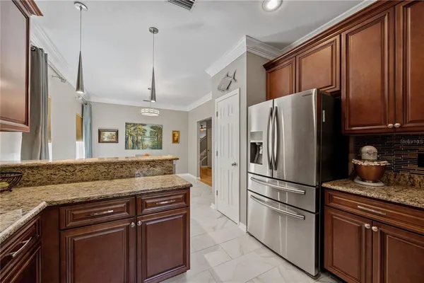 a kitchen with granite countertop stainless steel appliances a refrigerator and cabinets