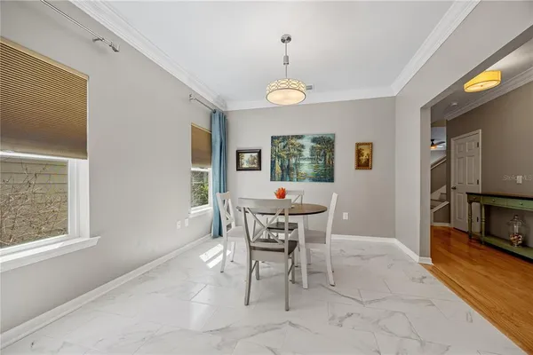 a view of a dining room with furniture a rug and wooden floor