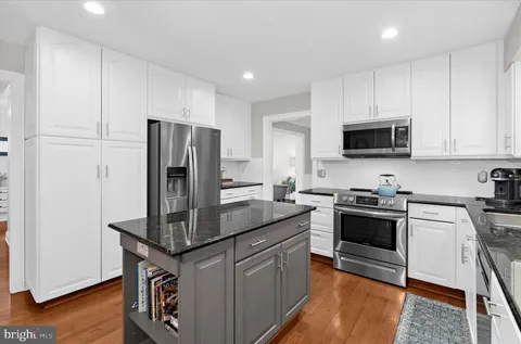 a kitchen with kitchen island a counter space and stainless steel appliances