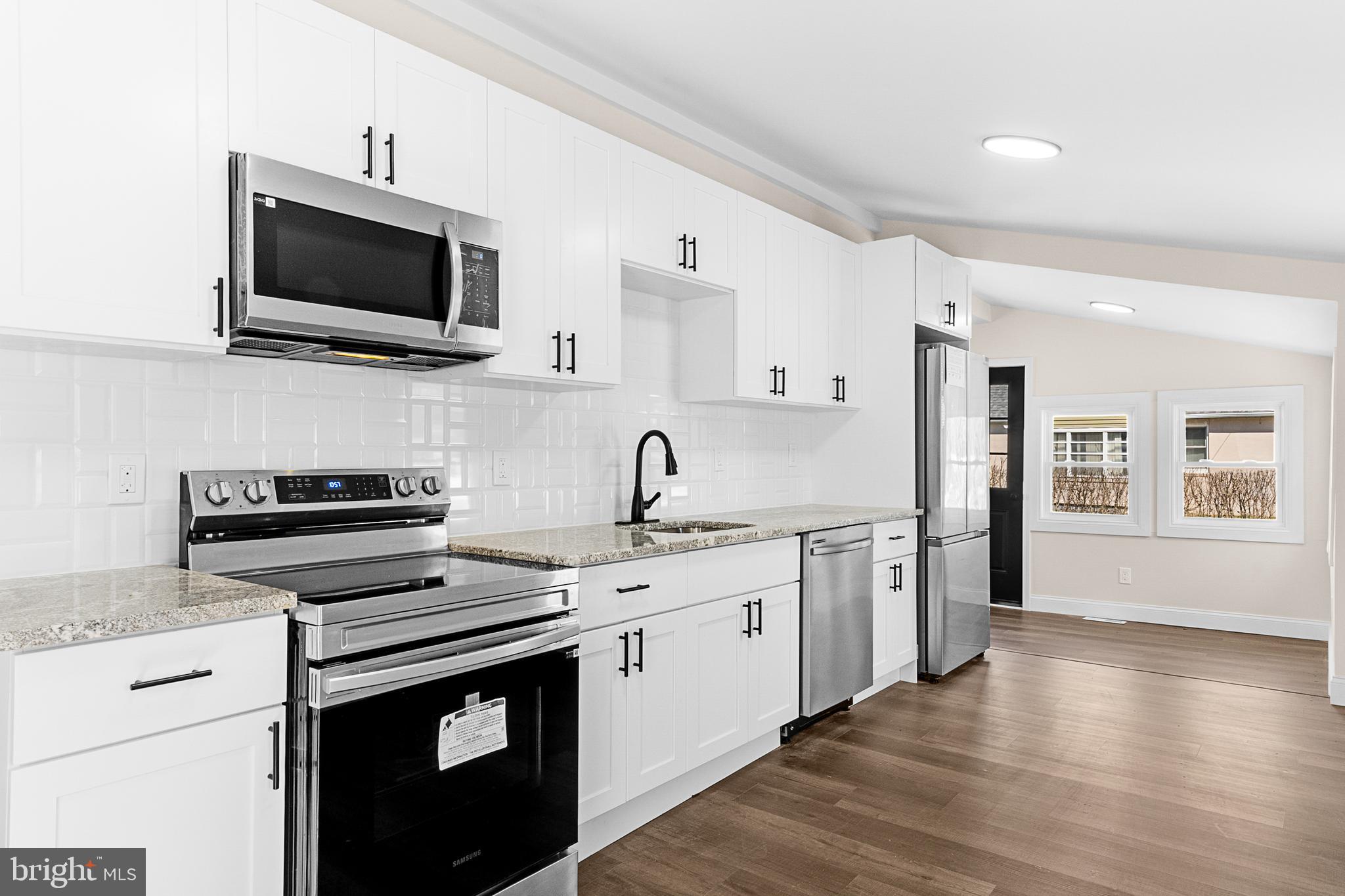 a kitchen with stainless steel appliances a stove microwave and a sink