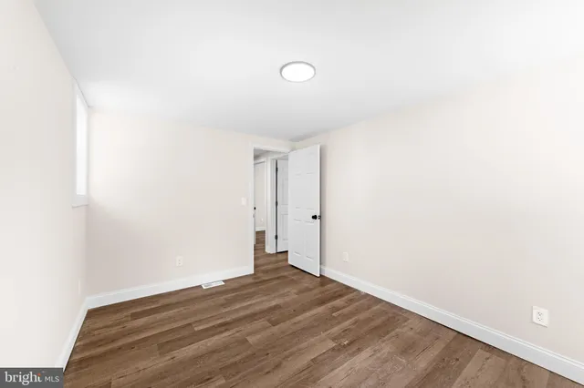 a view of a room with wooden floor and white walls