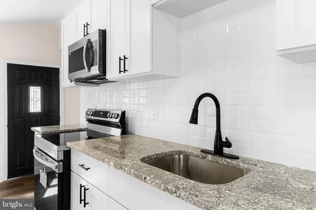 a kitchen with stainless steel appliances granite countertop a sink and granite counter tops