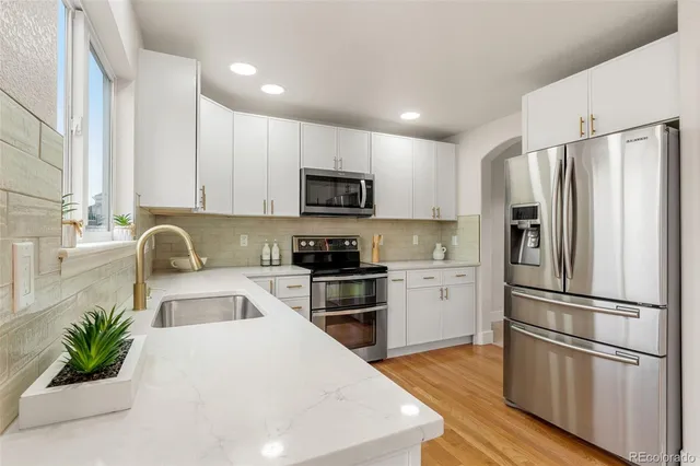 a kitchen with a refrigerator cabinets and a wooden floor