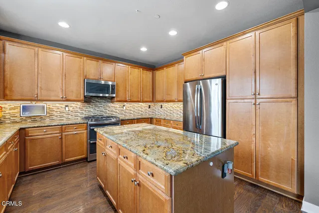 a kitchen with a refrigerator sink and cabinets