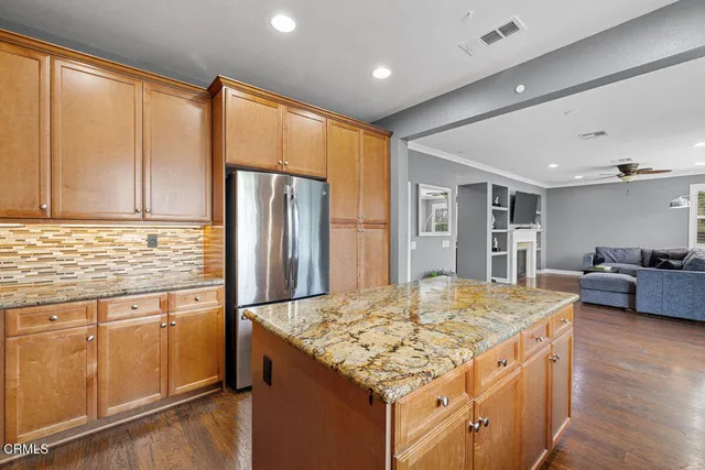 a kitchen with kitchen island granite countertop a sink stove and refrigerator