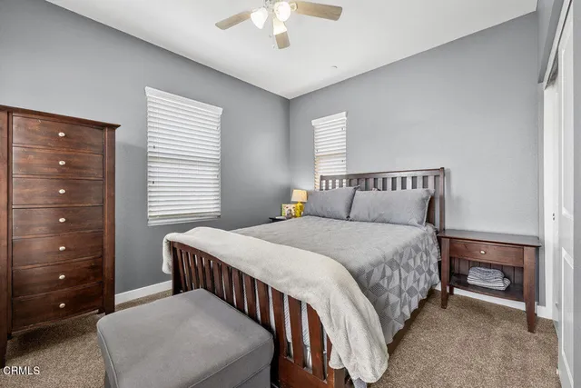 a bedroom with a bed a chandelier and a chair