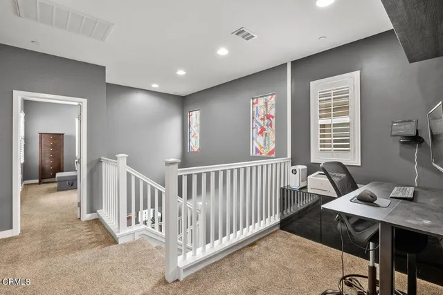 a view of a hallway with furniture and windows