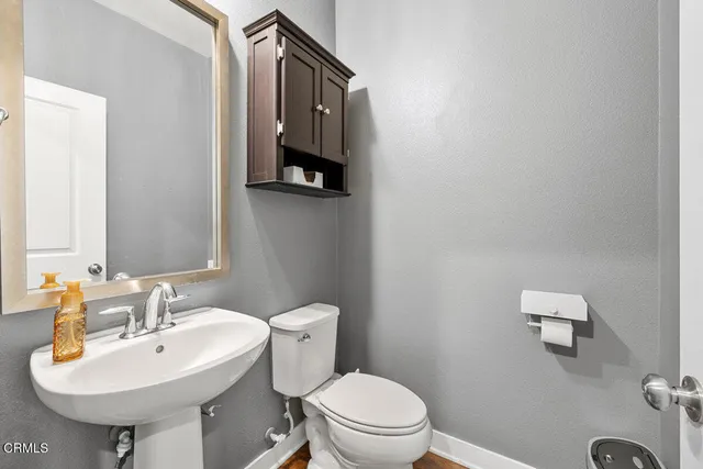 a bathroom with a sink a toilet and mirror