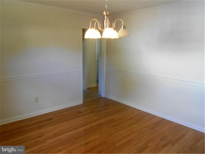 102 Devonshire Road Wilmington, DE 19803 - Photo 6 of 8 an empty room with wooden floor and windows