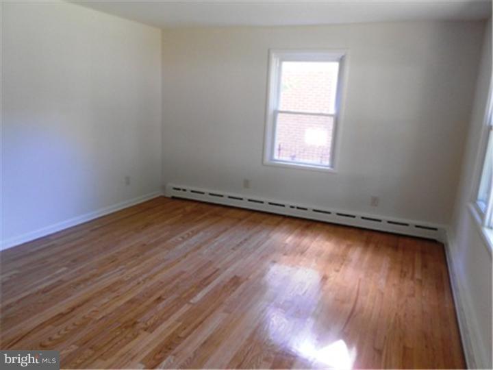 102 Devonshire Road Wilmington, DE 19803 - Photo 7 of 8 an empty room with wooden floor and windows