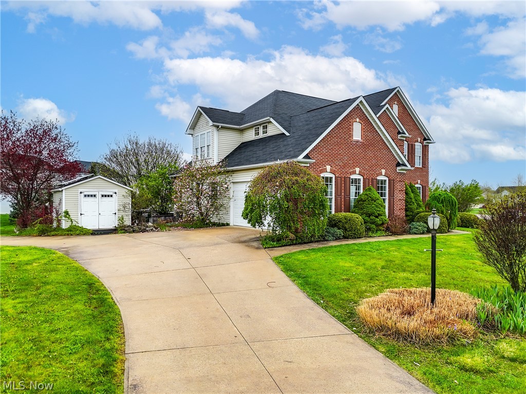Front of property featuring a sideload garage and a storage shed.