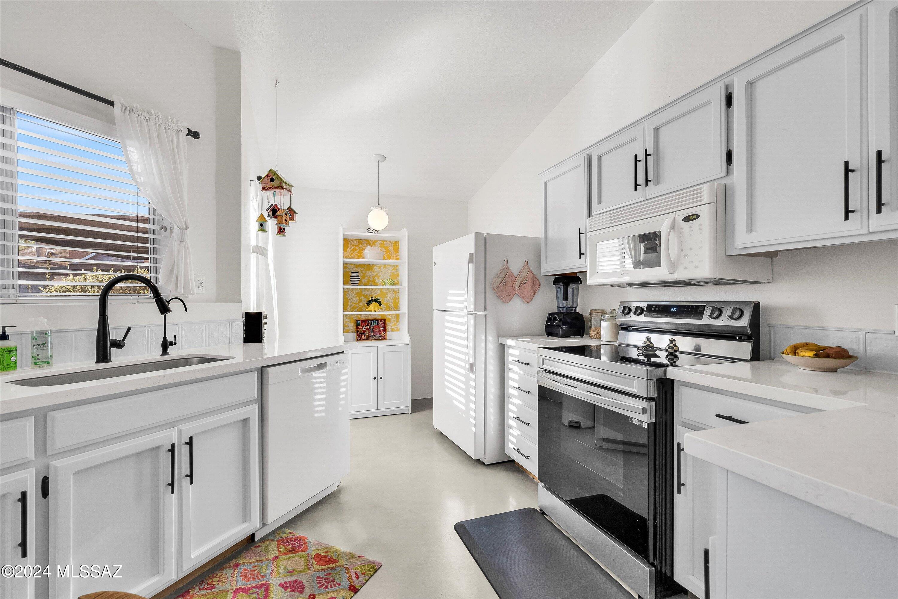 4309 East Presidio Road Tucson, AZ 85712 - Photo 5 of 28 a kitchen with white cabinets and white appliances