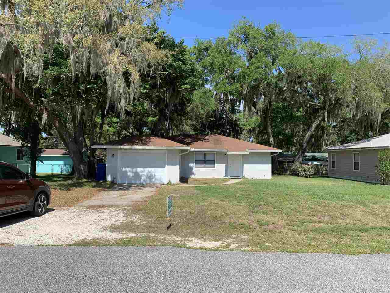 a front view of a house with a yard and trees