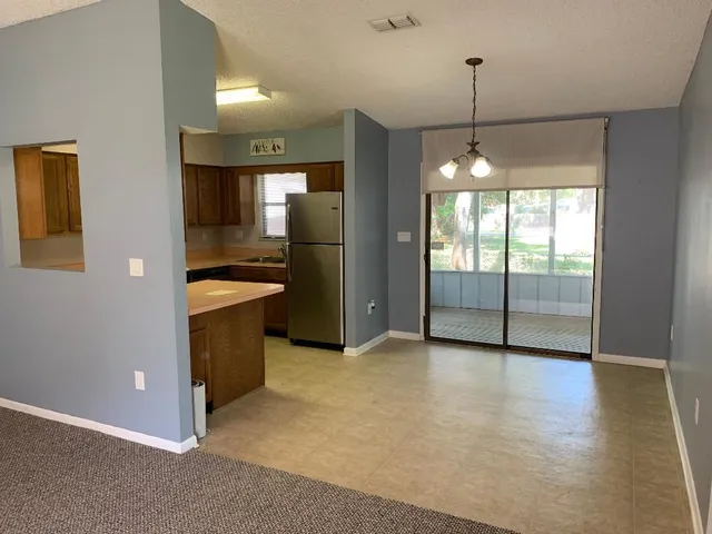 a view of a kitchen with a sink and an empty room