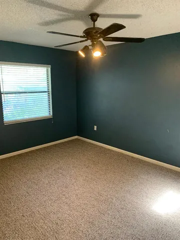 an empty room with a fan and window