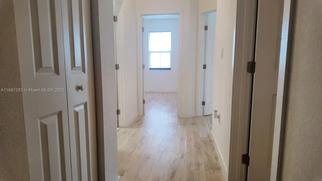 a view of a hallway with wooden floor